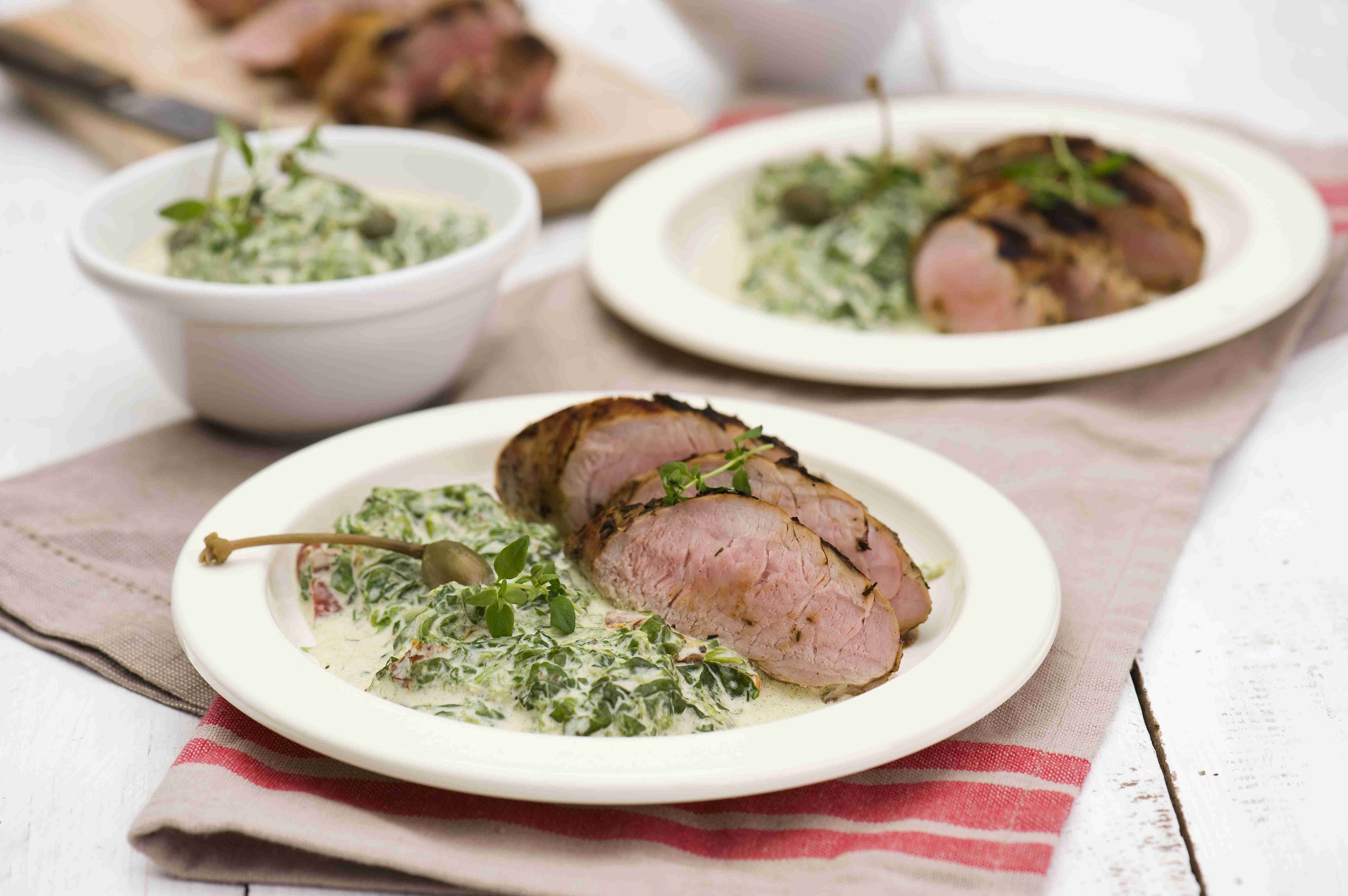 Marinated pork tenderloin steaks with spinach and cheese sauce