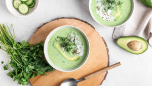 Zupa bez gotowana na lato - Chłodnik z warzyw sezonowych. Na zdjęciu zielony chłodnik z ogórków, awokado, pietruszki i groszku